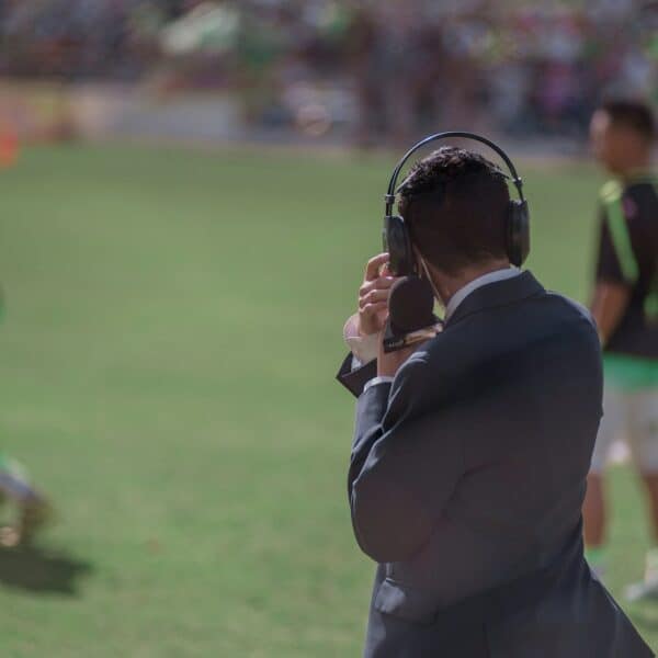 selective focus photography of man using headphones near athletes